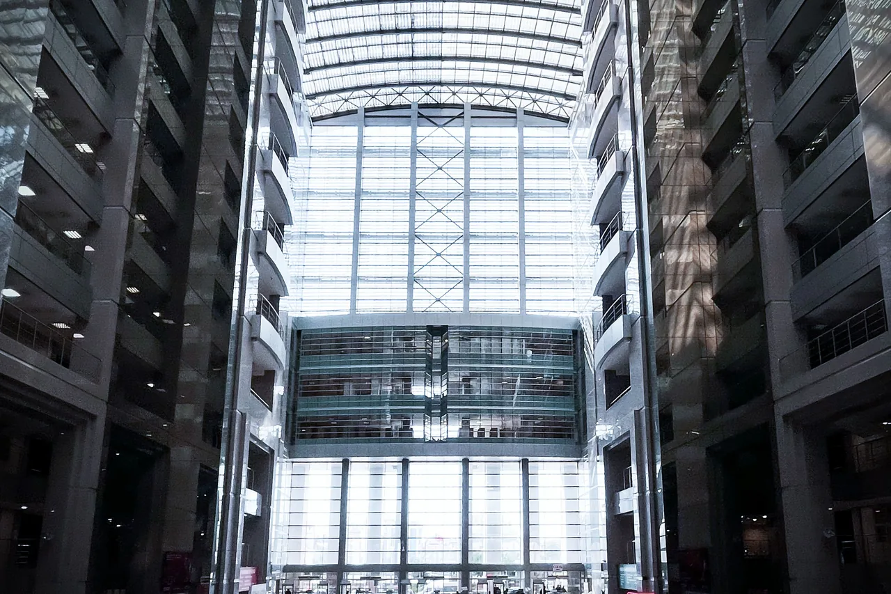 An office atrium rising toward a glazed roof